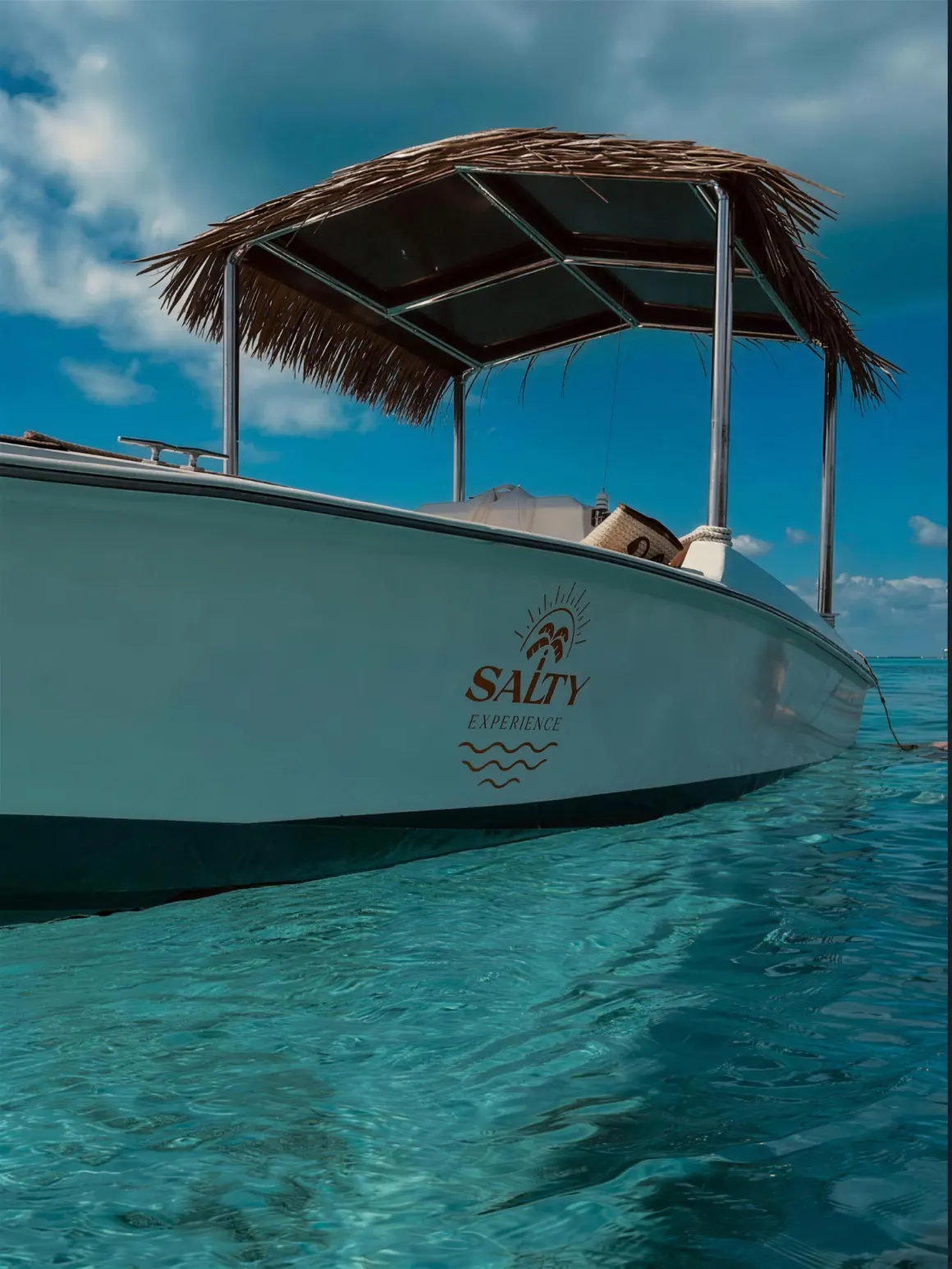 La Segunda, Salty Experience's 9-guest snorkel boat, anchored over turquoise water with the Salty Experience logo on the hull